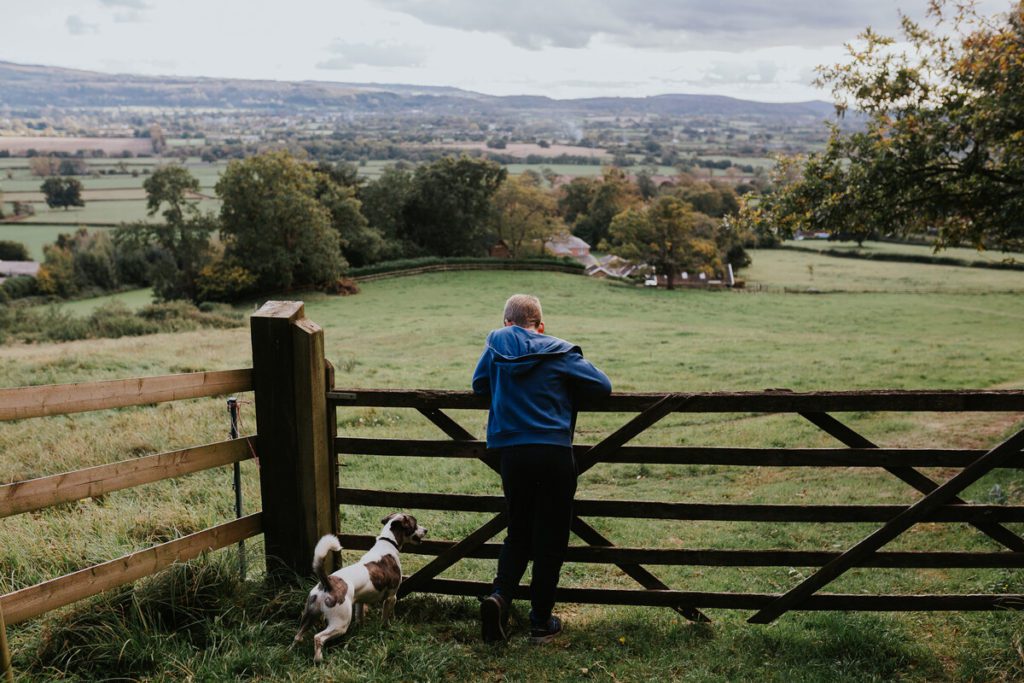 child and dog leaning on farm gate