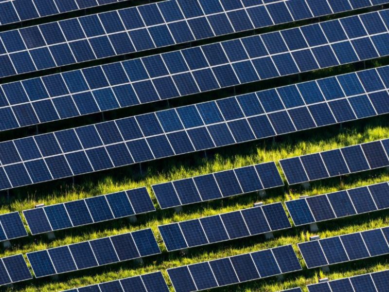 an image of hundreds of solar panels covering a field