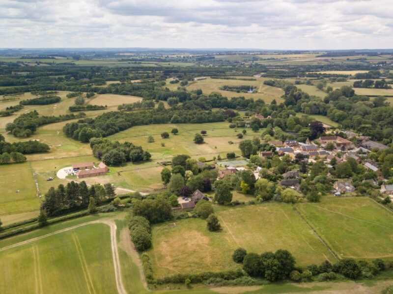 An aerial view of open countryside with Waterstock Village to the right and including part of the unintrusive golf course to the left.