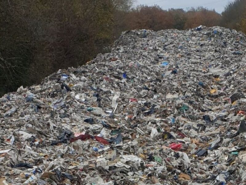 A pile of waste reaching into the disctance between hedgerows