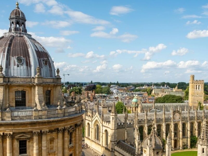 A view looking out across the rooftops of Oxford City on a sunny day with partly cloudy sky