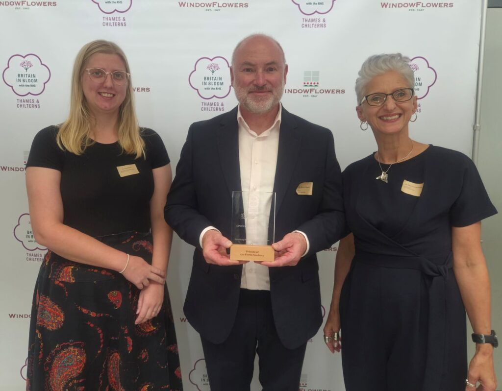 Marcus Gilleard presents the award to Newbury representatives: Anna Roberts from Newbury Town Council, and Sukey Russell-Hayward, a local volunteer