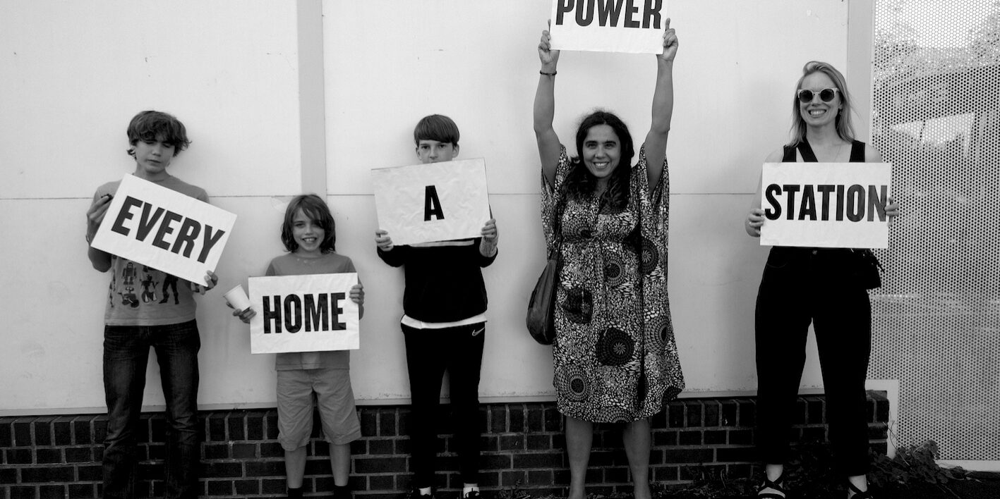 Children hold signs which read 'Every Home a Power Station'