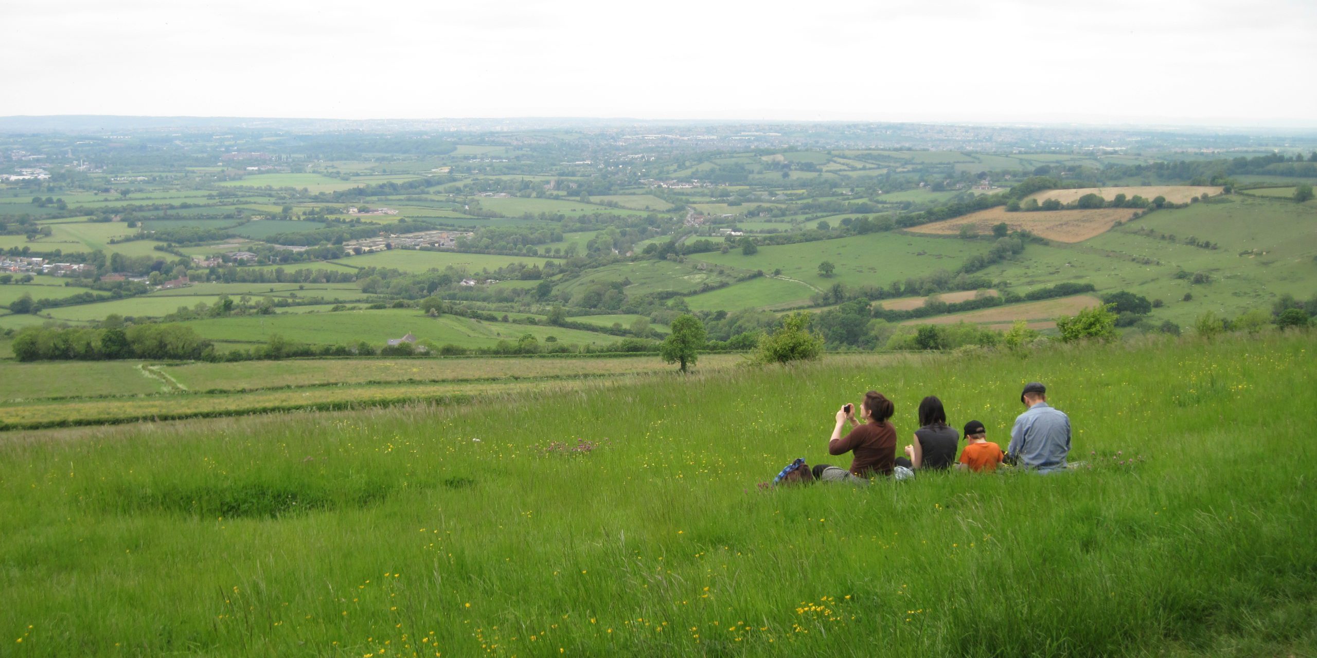 RS384_Group sitting on grass taking photos of the view