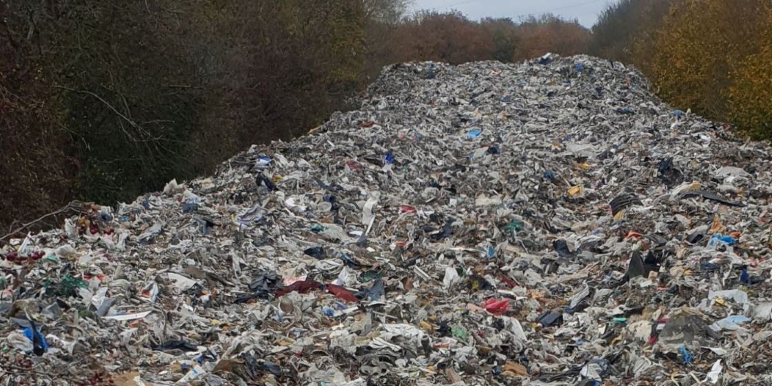 A pile of waste reaching into the disctance between hedgerows